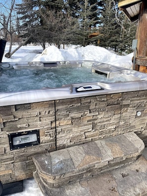 Unwind in a cozy barrel sauna under the Northern Lights, offering a serene Alaskan escape in winter.