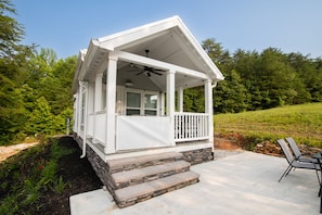 Covered front porch with oversized ceiling fan and toddler-friendly gate.