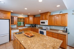 The fully stocked kitchen includes plenty of counter space and an island for seating