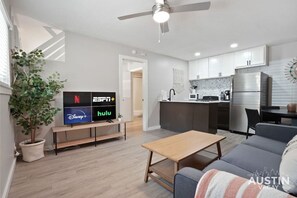 Living room with sleeper sofa, smart tv, full kitchen, and dining