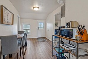 Eat-in Kitchen with view of the entry door. Kitchen includes all major appliances and a dining table with chairs as well as kitchen essentials. 