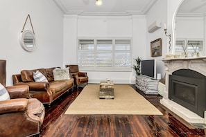 Cozy family room with fireplace, TV, AC, fan.