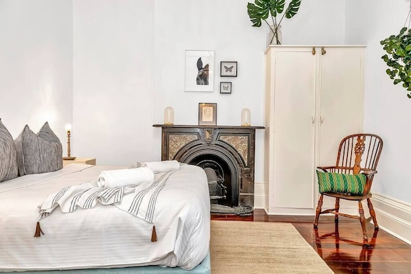 Luxurious master bedroom: king-size bed, elegant shutters, wall-mounted AC for comfort.