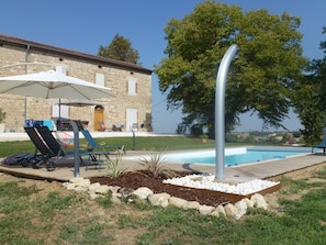 Pour apprécier la piscine : transats, parasol et une douche solaire