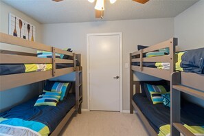 Two sets of bunkbeds with extra bedding, storage and toys in the closet.