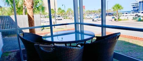 Screened in front porch with dining area and view of Ocean Blvd