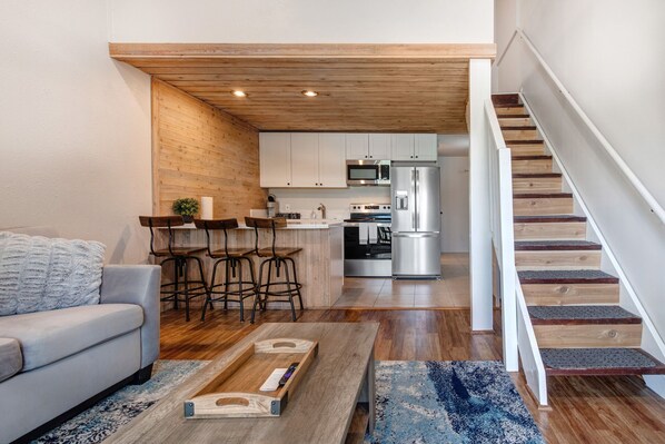 Cozy space with sofa bed, center table, and loft bedroom access.