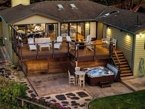 Luxury outdoor area with premium grill, fire table, plush seating, and hot tub