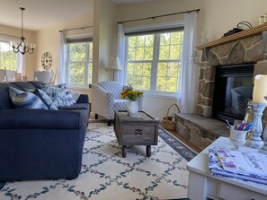 Open concept living room with propane fireplace, Smart TV, and sofa bed.