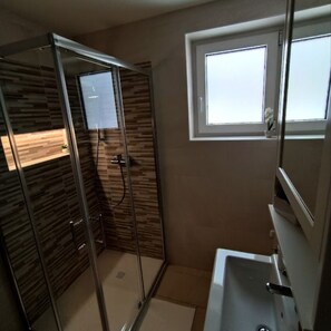 BATHROOM WITH SHOWER CABIN, TOILET, BATHROOM CABINET, WASHER AND DRYER