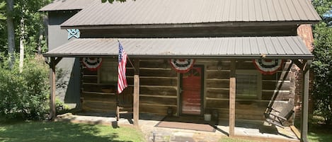 View of the front of the cabin with front porch swing