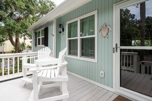 Head up the steps to the front porch. A.cute bistro table with attached Adirondack chairs is the perfect morning coffee spot.