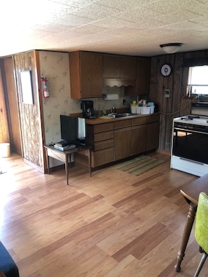 Kitchen area features full gas range, dishes, glassware, pots, pans, silverware, utensils, and more.