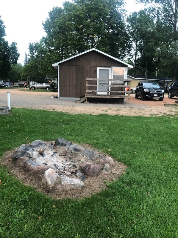 Quaint cabin features a small porch with only a few steps to enter