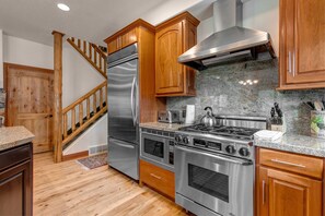 Fully Equipped Kitchen with gorgeous stone countertops, stainless steel appliances, hardwood floors, and island seating for 2