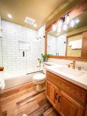 Bright and warm renovated bathroom on first floor with tub for soaking.  Solid wood flooring throughout even in bathrooms to prevent stepping out into the cold floor during the winter. 
