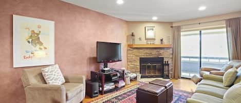 The inviting living room places a focus on comfort with a plush couch, cozy recliner, reading chair and two ottomans for you to kick back and relax. A beautiful stone fireplace, media console & flat-screen TV round out the space.