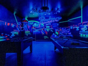 Retro themed game room in garage with pool table and foosball