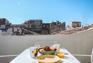 Terrace with a 180° view over the red slate roof tops of Arles. 