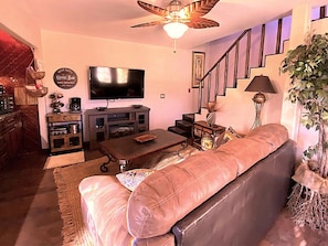 Livingroom with large screen TV, kitchenette and stairway to Master Suite