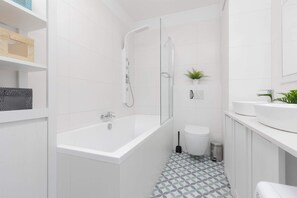 The bathroom features a modern bathtub and sleek fixtures. 