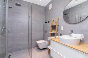 The bathroom's contemporary design includes fresh towels and a hairdryer. 