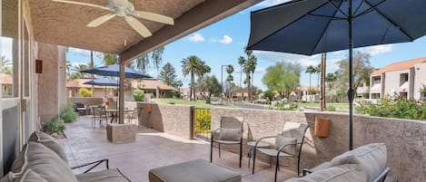 A sprawling and spacious patio for your leisure, that opens up to a large grass area.