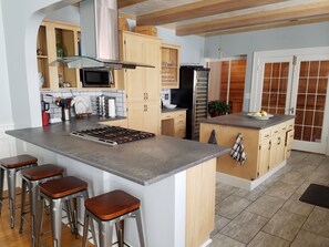 Bar stools to French doors into back hall. Wine chiller for BYOB wine/beer.