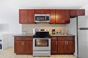 Modern kitchen with basic appliances, sleek counters, and stylish cabinetry