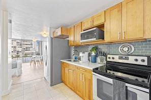 Modern kitchen with basic appliances, sleek counters, and stylish cabinetry