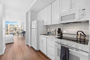 Modern kitchen with basic appliances, sleek counters, and stylish cabinetry