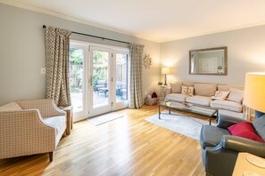 The sunny spacious living room has views of the private back deck.
