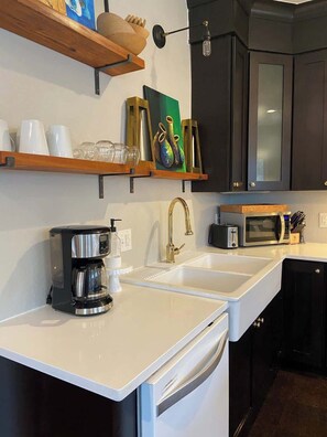Coffee, microwave, toaster and farmhouse sink.