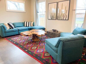 Living room next to the kitchen overlooks the front porch and garden