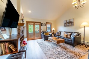 Living area offering cozy furnishings, a gas fireplace and mounted smart TV.