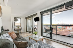 Floor to ceiling glass doors allow lots of natural light and views across the roof tops.