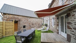 Garden with table, recliners, sofa set and barbecue.