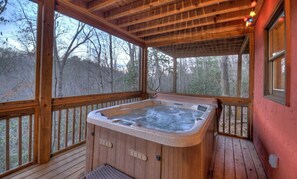 Relax in the steamy hot tub with serene wooded views on the covered deck.