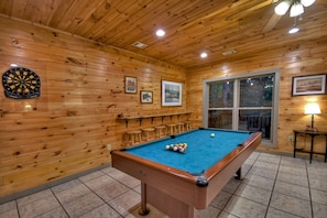 Indoor Game Room with a Pool Table, Bar Stools, and Mounted Table