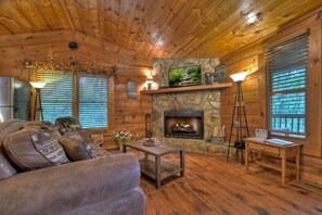 Cozy living room with a stone fireplace and comfortable seating.