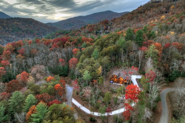 Private cabin nestled among vibrant fall foliage, with stunning mountain views.