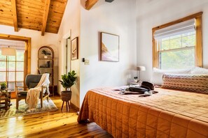 A loft space that is inviting. Seating area for two and a cozy bed. Connected to private bathrom.