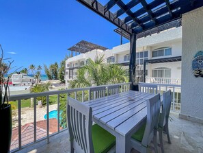 Balcony with dining over look community pool and Turquoise water