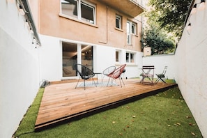 Spacious backyard with a wooden deck and cozy seating, ideal for outdoor dining and relaxation in a private setting.