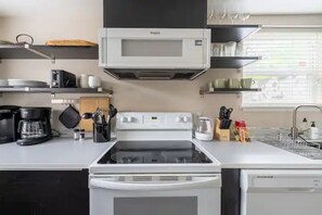 Galley kitchen with microwave, electric glass cooktop stove, dishwasher