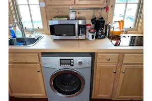 Kitchen sink, microwave, washer/dryer, induction stovetop, kettle, coffee maker