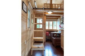 View of Twin loft with library ladder and below seating/dining area