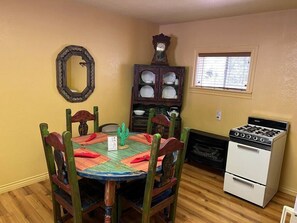 Dining area and small kitchen stocked with cooking amenities. 