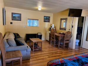 Living area includes a small dining table, mini-fridge, microwave, coffee maker, and TV with Dish TV service.