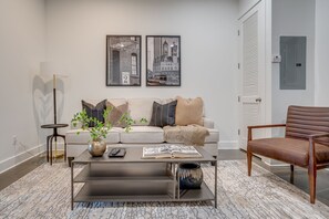 Open concept living area with designer furnishings and smart TV.
